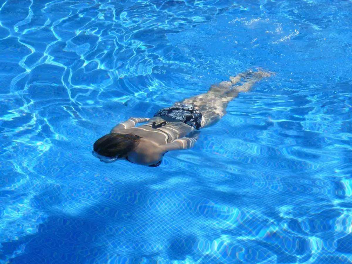 Femme nageant la tête sous l'eau dans une piscine